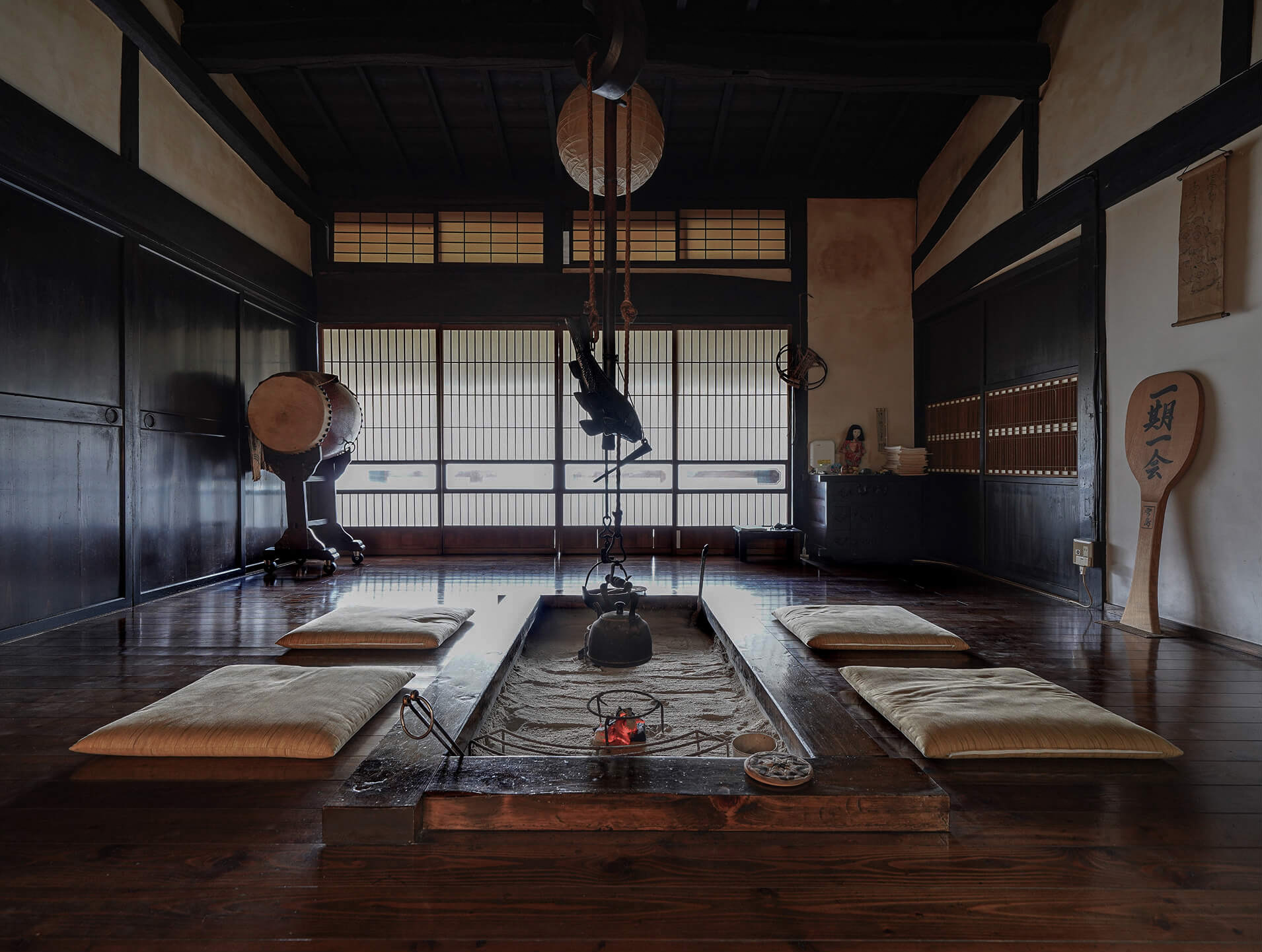 古い木造で、中央に囲炉裏があるメインルーム